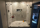 Custom frameless glass shower enclosure with marble tile